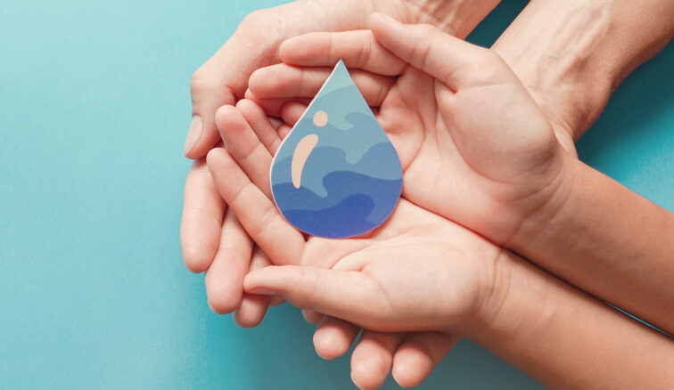 Adult and child hands holding paper cut water drop, World Water Day.
