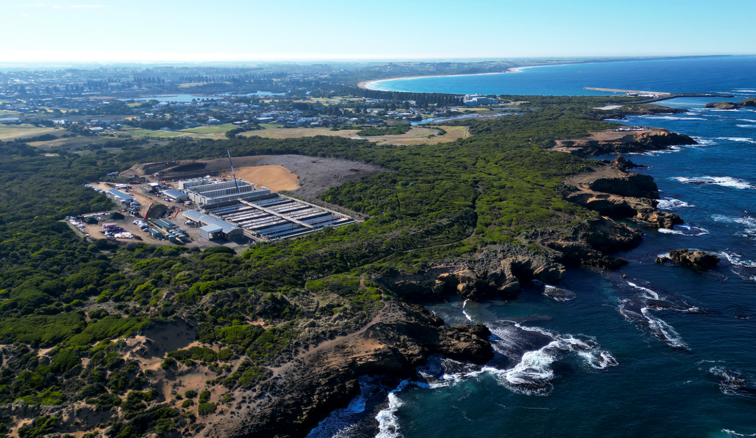 Aerial photo of Warrnambool Sewage Treatment Plant with ocean in foreground and city in background